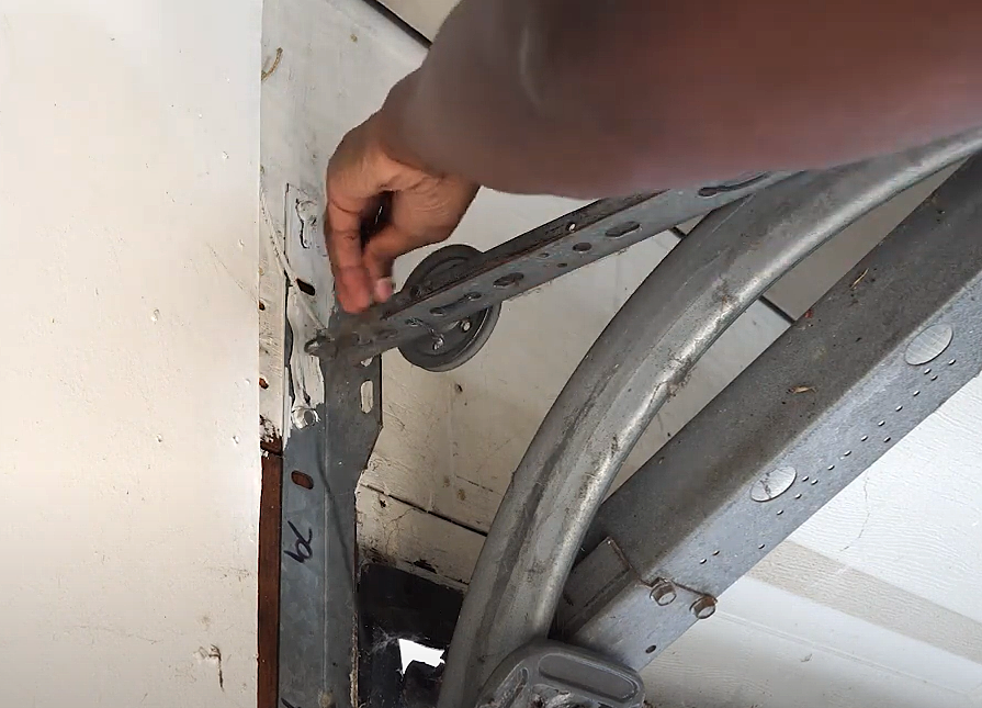 Technician repairing a garage door track with tools in a residential garage in Bradenton, FL – garage door track repair.