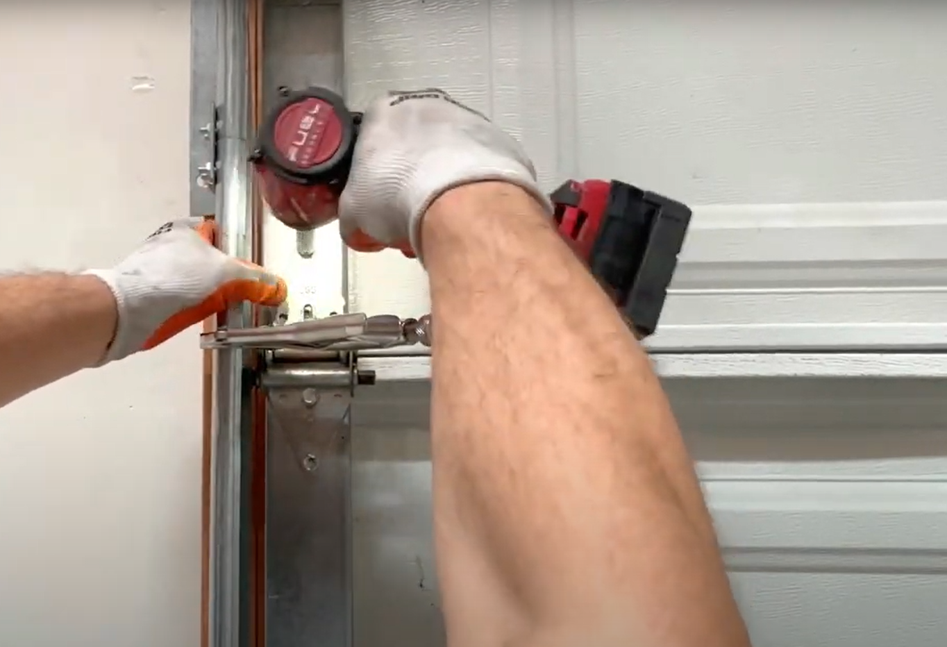 Professional technician fixing a noisy garage door in Bradenton FL by inspecting and adjusting the noise reduction mechanism.