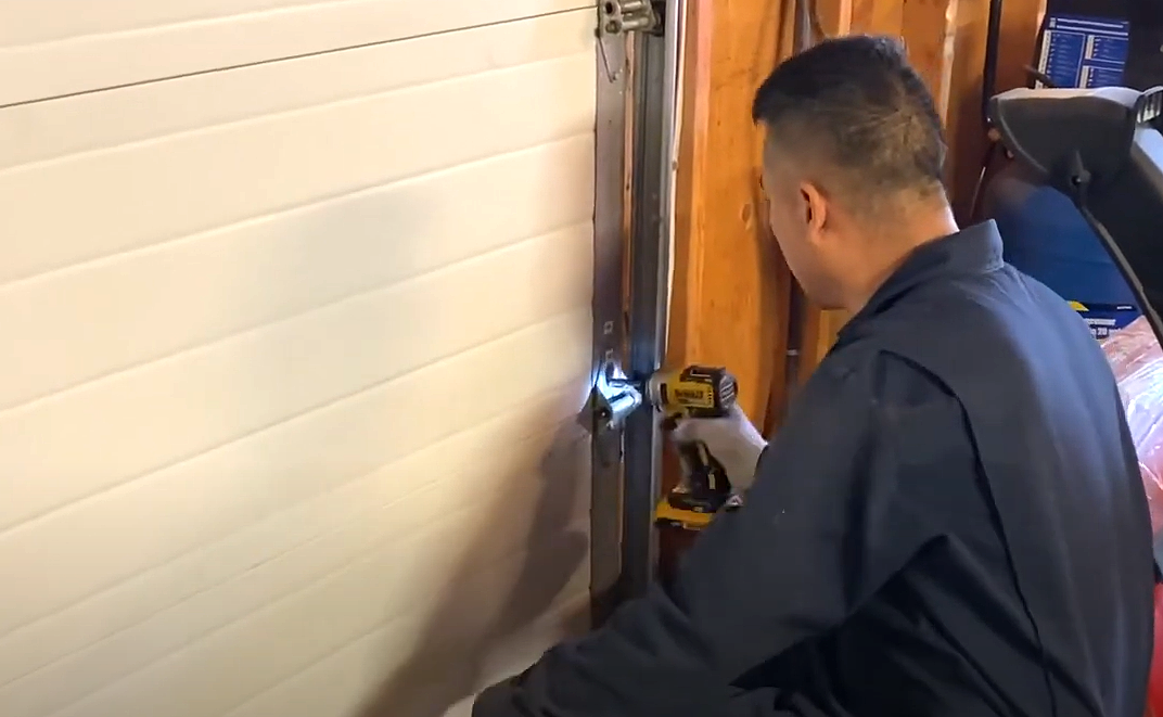 Professional technician performing garage door section replacement, showcasing the expertise and service quality of Bradenton FL Garage Door Repair.